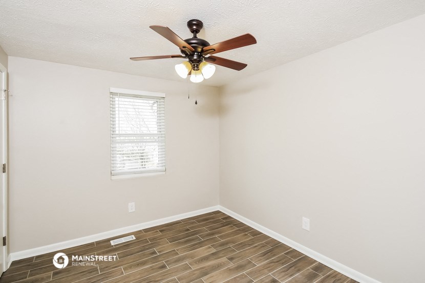 a living room with a ceiling fan and a window
