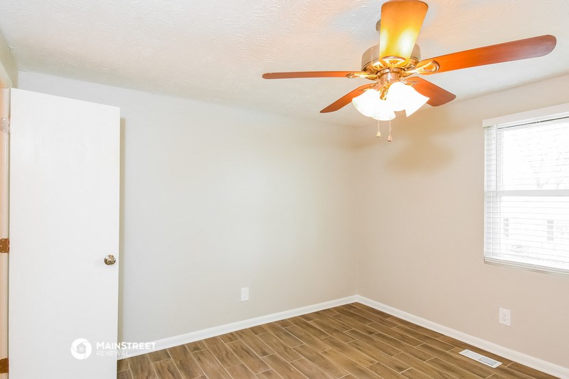a bedroom with a ceiling fan and a window