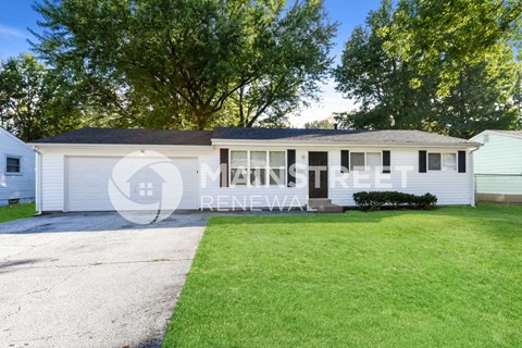 a small white house with a lawn in front of it