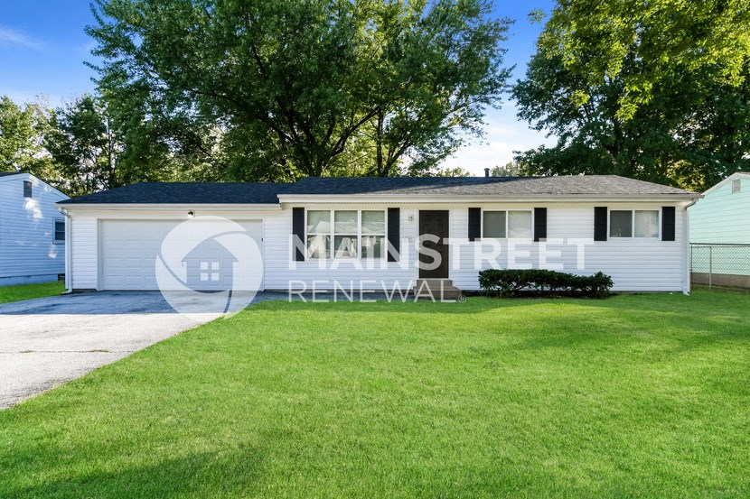a small white house with a lawn in front of it