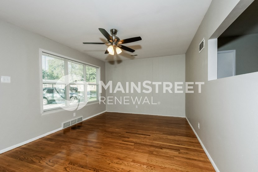 a living room with a wood floor and a ceiling fan
