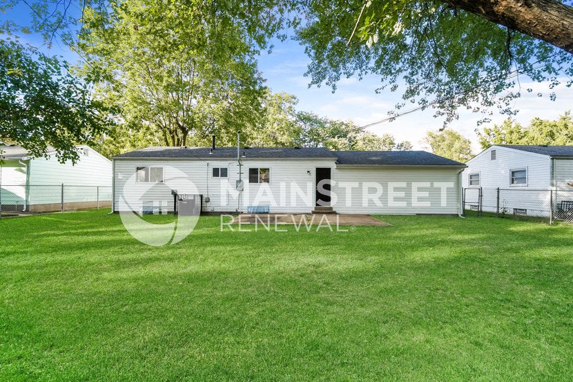 a small house with a yard and a garage