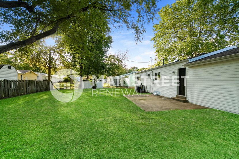 a backyard with a shed and a garage and a yard with grass