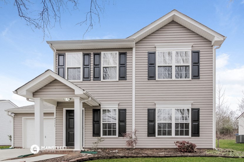 a white house with black shutters and black windows