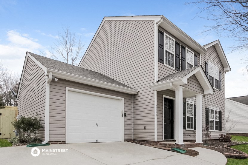 a white house with a white garage door in front of it