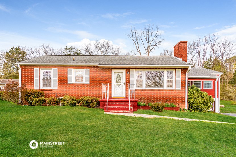 a red brick house with a lawn in front of it