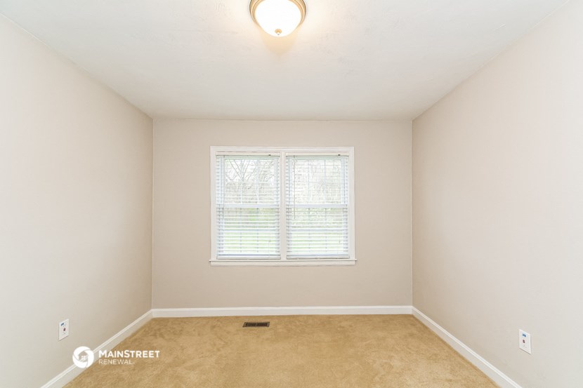 the spacious living room with a window and carpeting