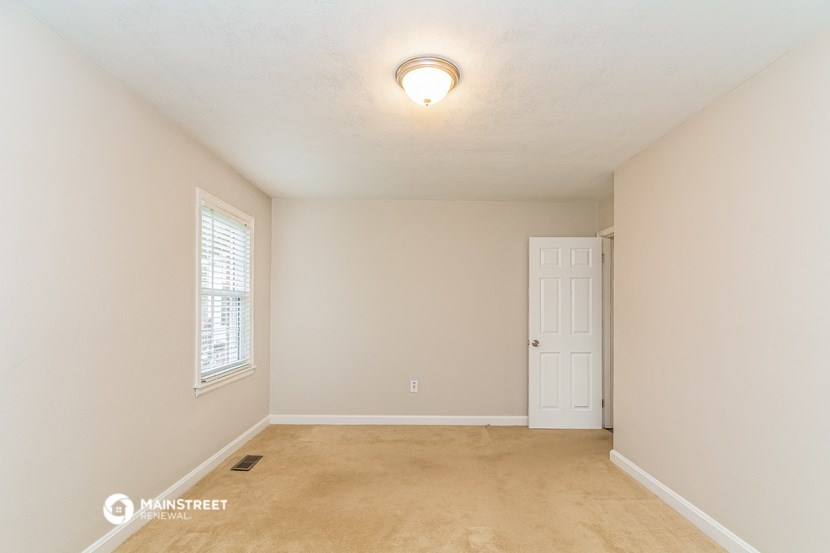 the spacious living room with a door to the bedroom
