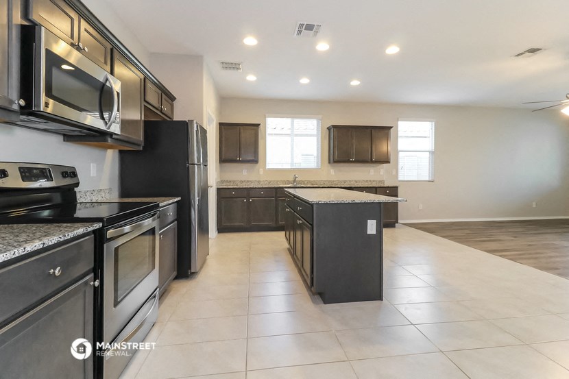 a large kitchen with stainless steel appliances and marble counter tops