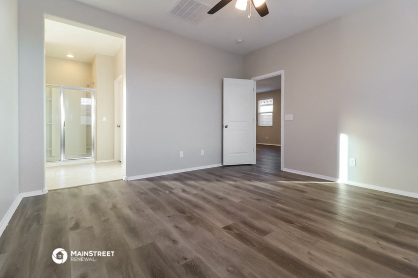 an empty living room with wood flooring and a white door