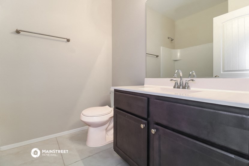 a bathroom with a sink toilet and a mirror