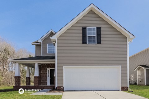 a tan house with a white garage door