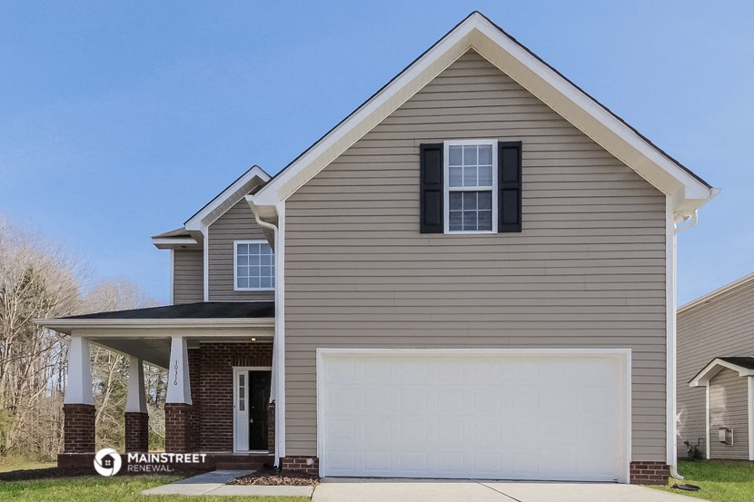 a tan house with a white garage door