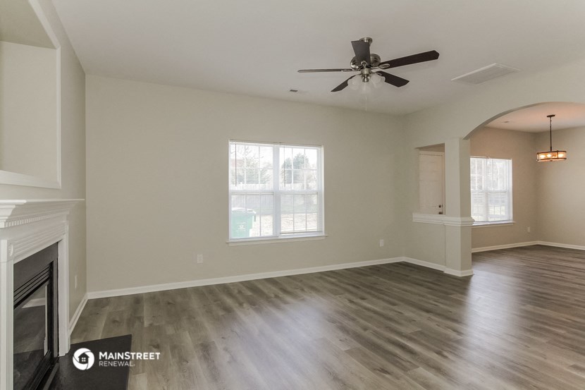 the living room with fireplace and ceiling fan