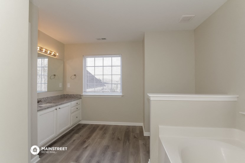a bathroom with a tub and a sink and a window