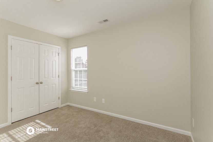 a bedroom with a closet and a door and a window
