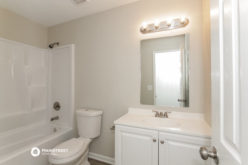 a bathroom with a sink toilet and shower and a mirror