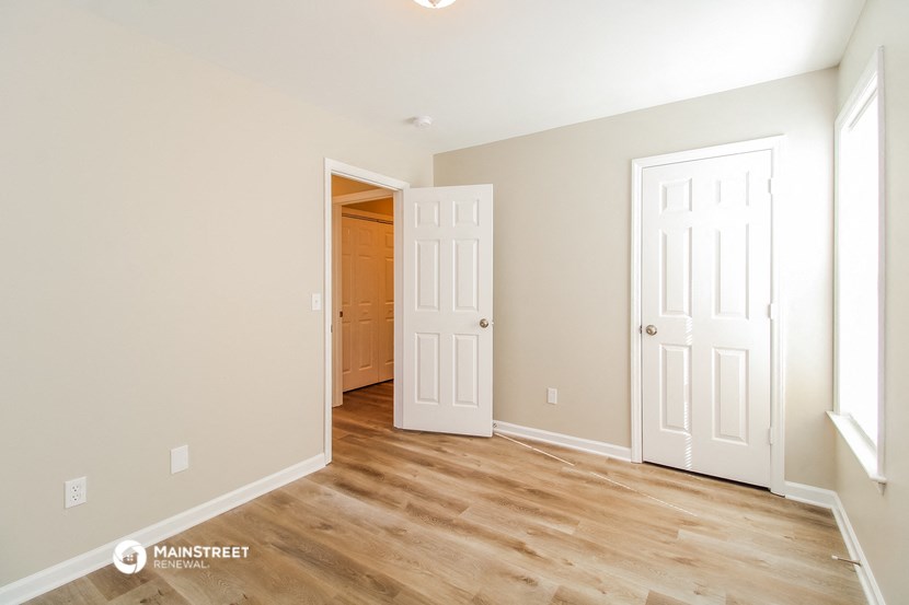 a bedroom with two doors and a door to a closet