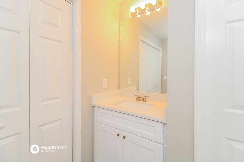 a white bathroom with a sink and a mirror