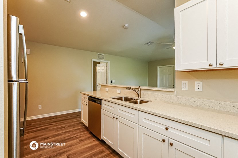 a kitchen with white cabinets and a sink and a refrigerator