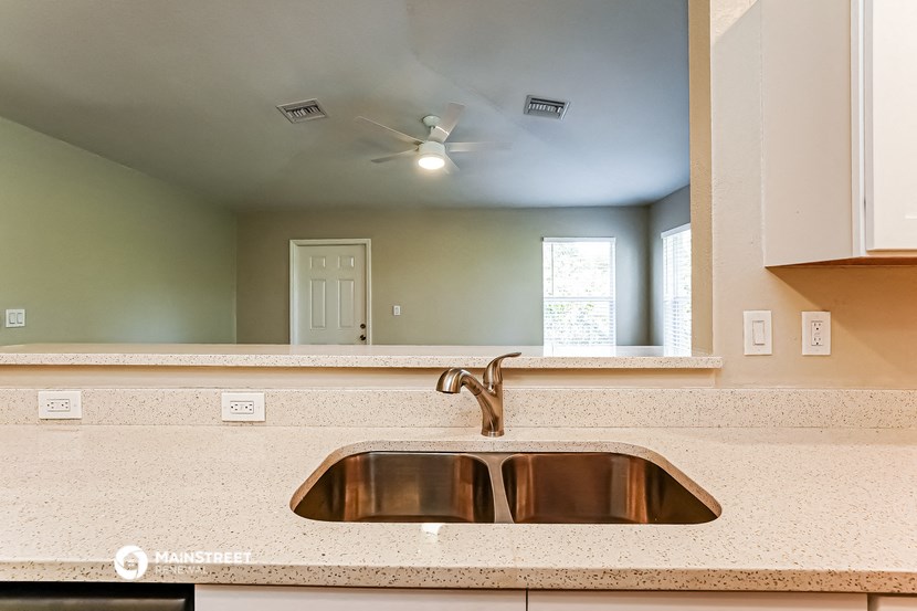 an empty kitchen with a sink and a mirror