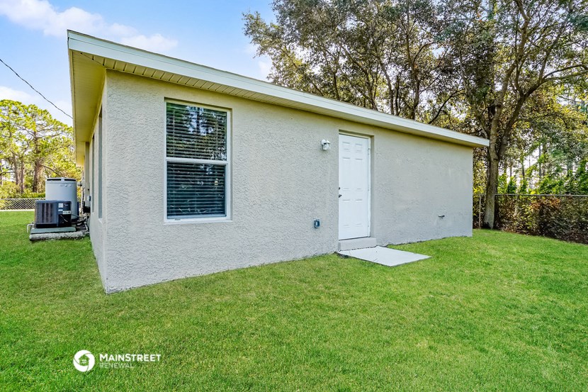 a small white house with a white door and a lawn