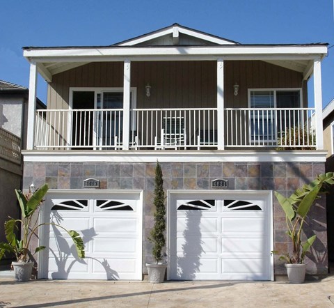 the front of our house with garages and a balcony