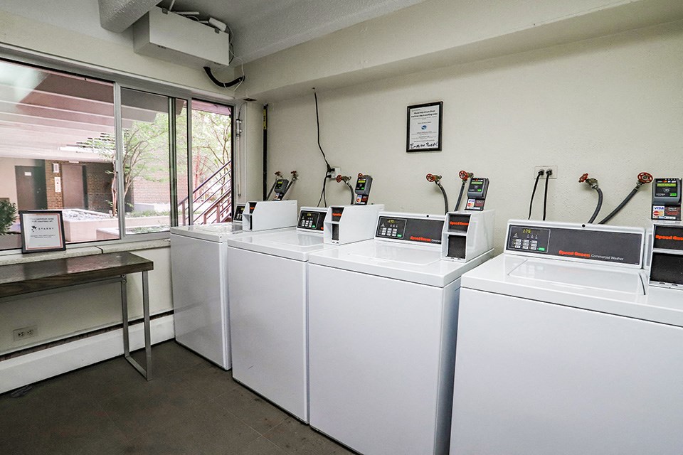 four washers and dryers in a laundry room with a window