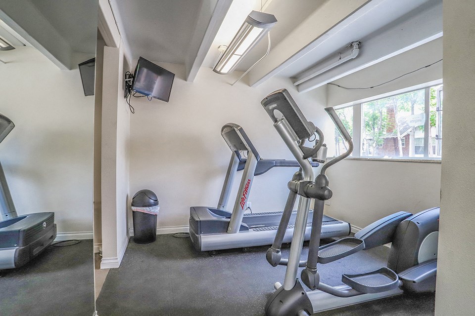 the gym has plenty of equipment and a window