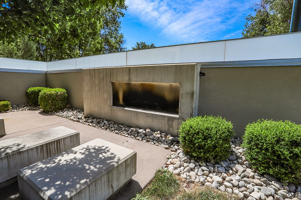 a courtyard with a bench and a building with a fountain