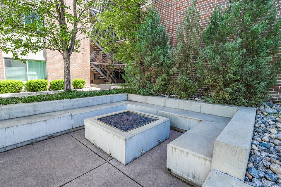 a courtyard with a water fountain in front of a brick building