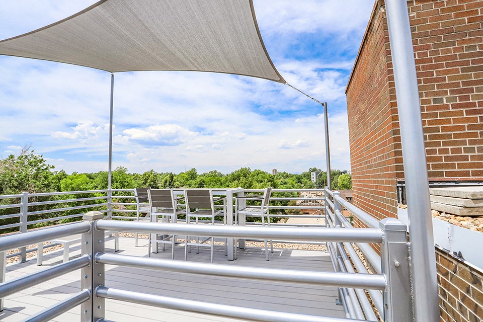 the upper deck of a building with tables and chairs on it