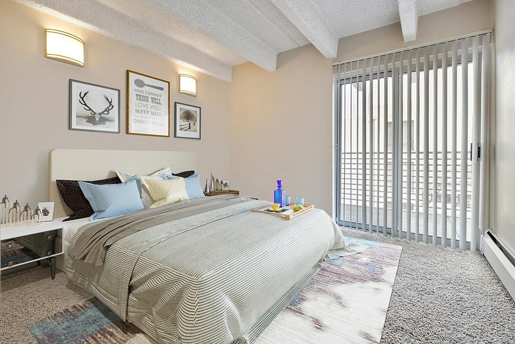 a bedroom with a large window and a bed