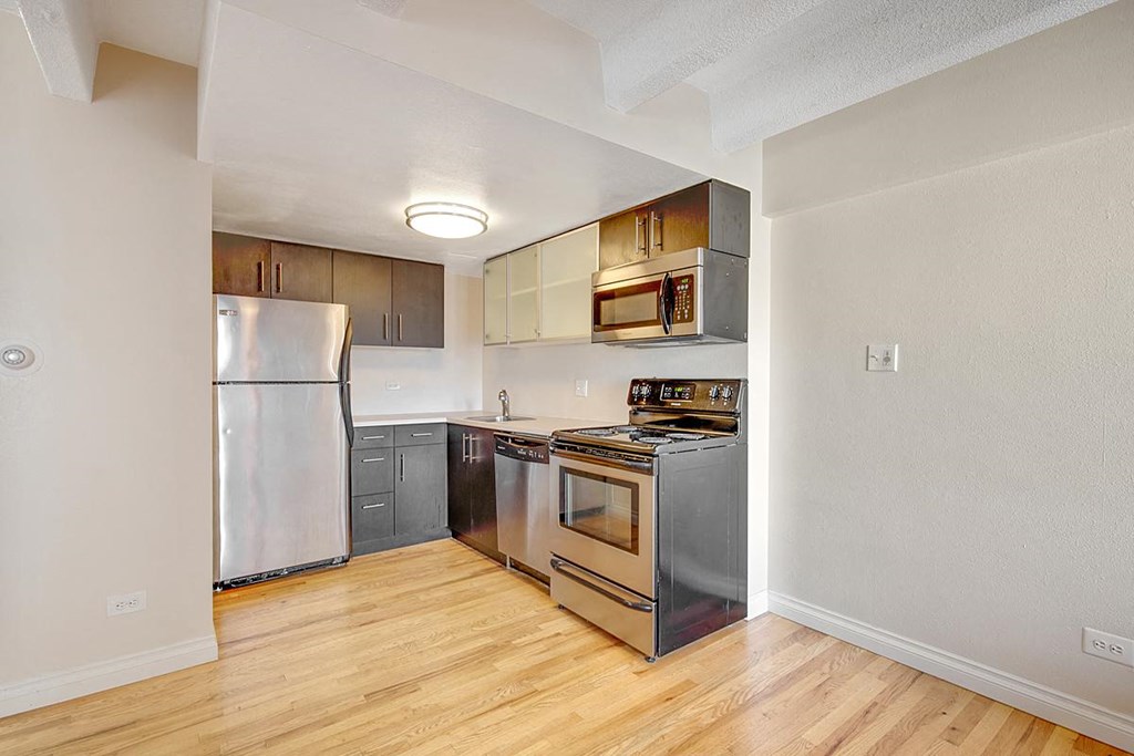 a kitchen with stainless steel appliances and a wooden floor
