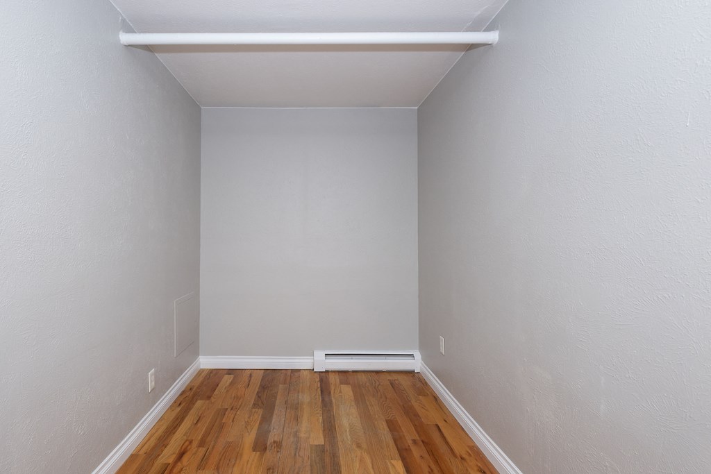 an empty room with wood flooring and gray walls