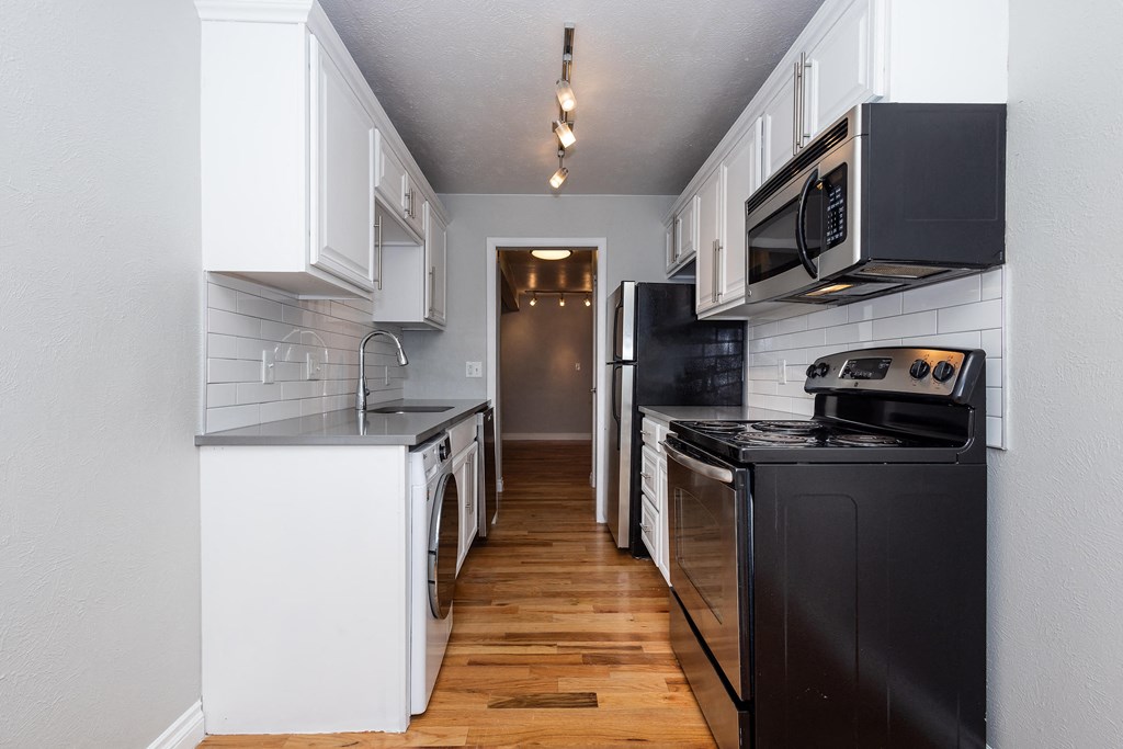 a kitchen with black appliances and white cabinets