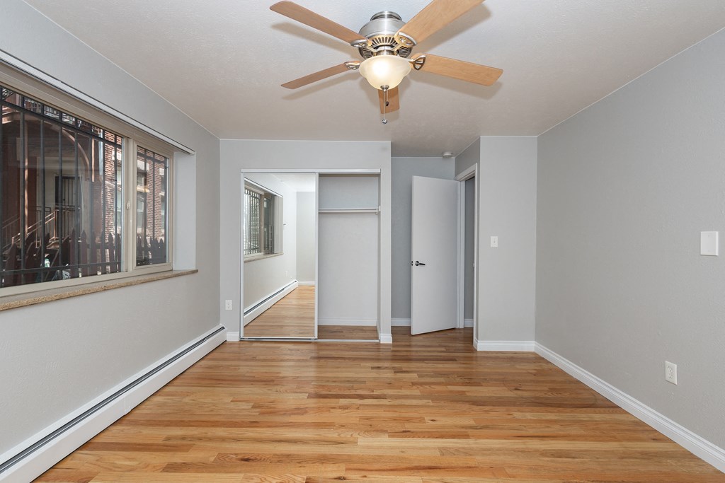 an empty living room with a ceiling fan and a window