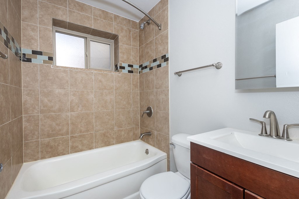 a bathroom with a tub sink toilet and a mirror