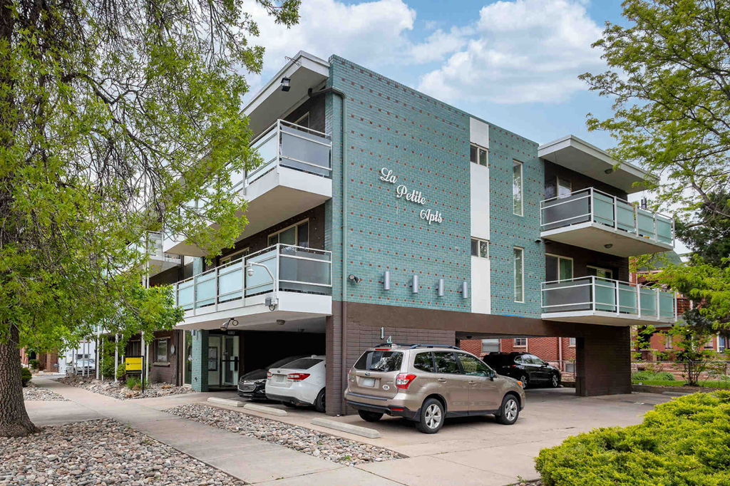 a building with a parking lot and cars in front of it