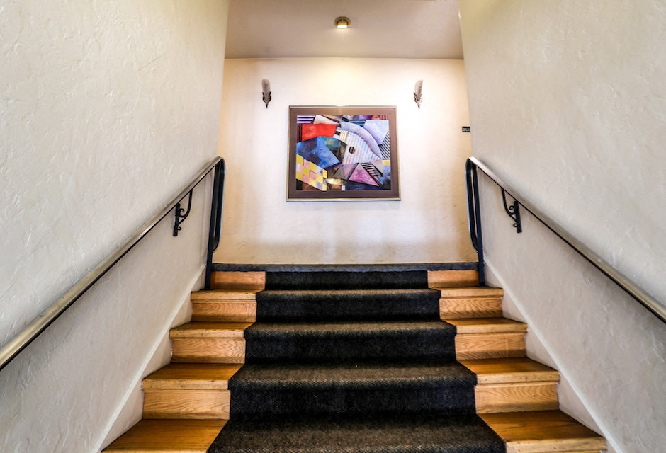 a staircase with wooden steps and a painting on the wall