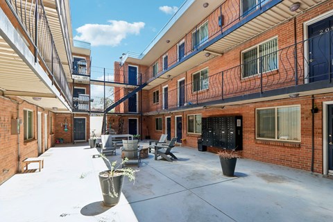 A courtyard with a bench and a potted plant.