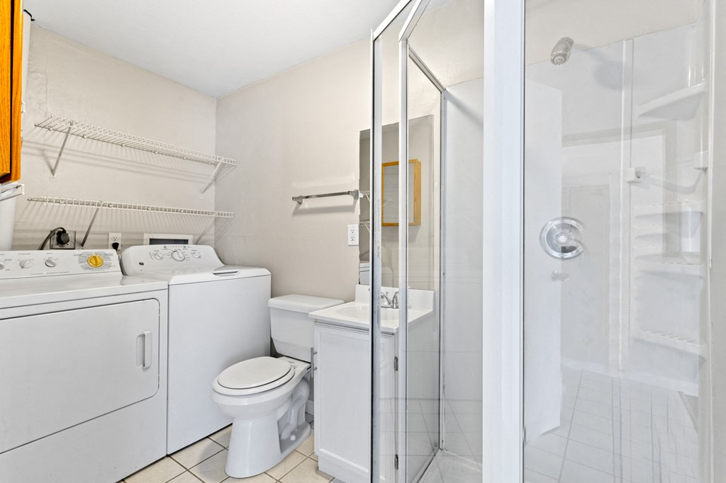 a bathroom with a shower toilet and a washer and dryer