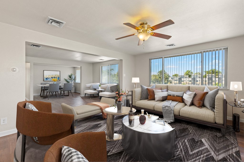 a living room with couches and a table and a ceiling fan
