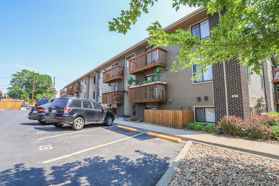 a parking lot with cars in front of an apartment building