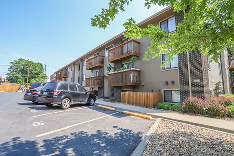 a parking lot with cars in front of an apartment building
