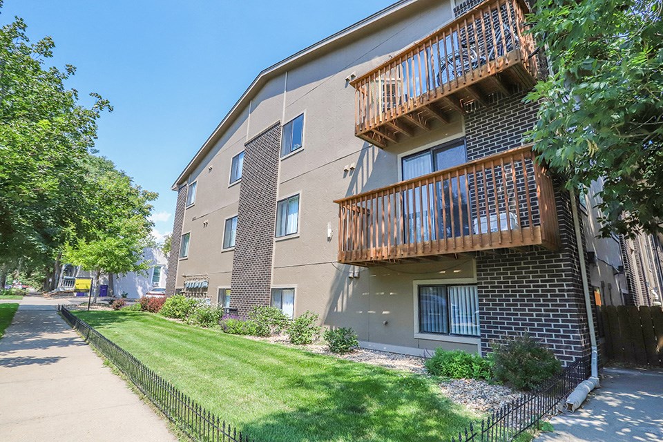 an apartment building with a yard and a balcony