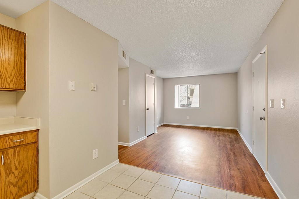 an empty living room and dining room with wood floors
