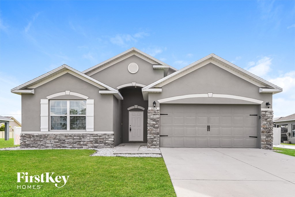 A modern house with a stone facade and two garages.