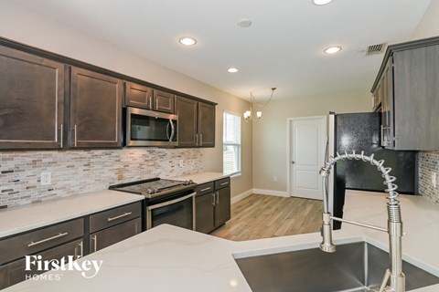 a kitchen with dark wood cabinets and white counter tops