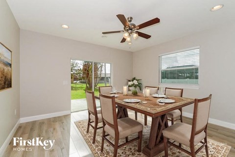A dining room with a wooden table set for four.